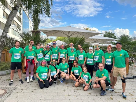 Mitarbeiter und Mitarbeiterinnenn sowie Schüler und Schülerinnen der Landesschule psoeren mit einheitlichen T-Shirts für ein Gruppenbild und lächeln in die Kamera.
