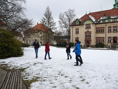 Schüler der Klasse 10a stehen auf der Wiese vor dem Haus 2 und begrüßen die Gäste.