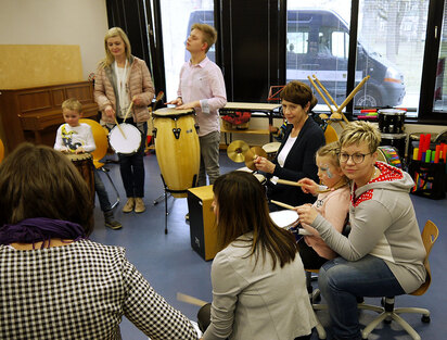 Im Musikzimmer des Hauses 35 trommeln Besucher und Dustin zusammen mit Kolleginnen unserer Schule.