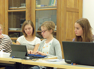 Drei Schülerinnen arbeiten an Laptops.