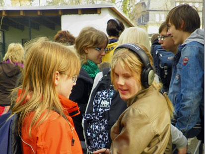 Ein Mädchen mit Kopfhörern steht in einer Schulgruppe.