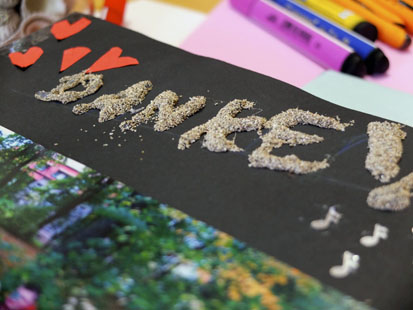 Das Wort Danke wurde mit Sand auf ein schwarzes Papier geklebt. 