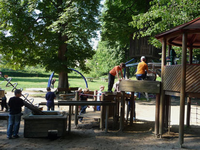 Viele Kinder tollen auf dem Abenteuerspielplatz.