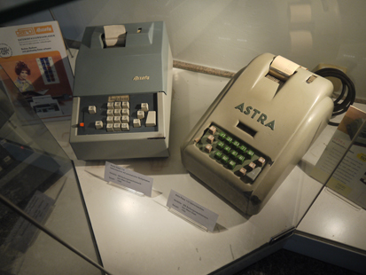 Das Bild zeigt zwei unterschiedliche Buchungsmaschinen der Firma Astra in einer Vitrine im Foyer der Landesdirektion.