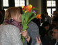 Eine Kollegin umarmt Frau Lehmann bei der Übergabe ihrer Blume.