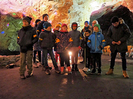 Die Theatergruppe steht vor der Felswand der Höhle.
