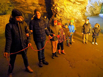 In der Höhle probieren die Kinder eine Übung mit einem Seil aus. In einer langen Reihe stehen sie hintereinander. Im Seil sind viele Knoten für eine besseren Orientierung.
