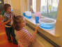 Zwei Schüler der Grundschule untersuchen Wassermengen.