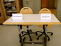 Schülertisch mit zwei Schildern auf denen einmal „Jugendgerichtshilfe“ und zum anderen „Staatsanwalt“ steht.