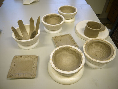 Auf einem Tisch stehen die fertigen Keramiken der Schüler zum Trocknen.