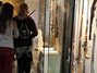 Schüler laufen an Waffen, die in Glasvitrinen hängen vorbei und schauen sich die ausgestellten Exponate an.