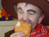 Junge als Cowboy isst einen Hamburger