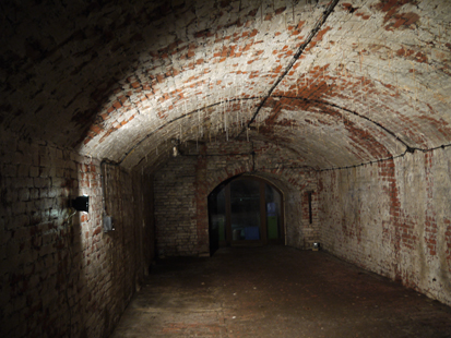 Das Bild zeigt das ausgemauerte Kellergewölbe, an dessen Decke die Stalaktiten, kalkhaltige Tropfsteine, hängen.