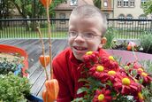 Junge freut sich über bunde Blumen.