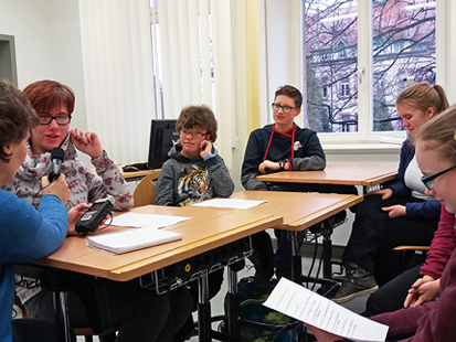 Eine Reporterin interviewt die Schüler der Klasse 8a im Klassenzimmer für einen Radiobeitrag.