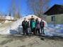 Alle 6 Teilnehmer stehen mit Frau Freygang vor einem riesigen Schneehaufen in der Nähe der Bungalows.