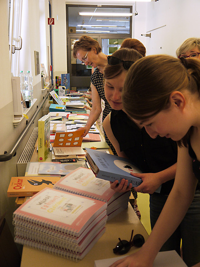 Zwei Schülerinnen und eine Lehrerin betrachten angeregt die Vielzahl an angebotenen Büchern auf dem Büchertisch der DZB lesen. Zwei Schülerinnen und eine Lehrerin betrachten angeregt die Vielzahl an angebotenen Büchern auf dem Büchertisch der DZB lesen.