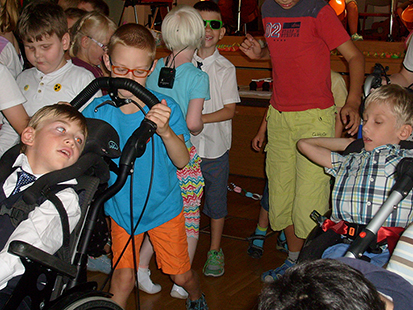 Die Grundschulkinder tanzen mit den Schulanfängern vor der Bühne.