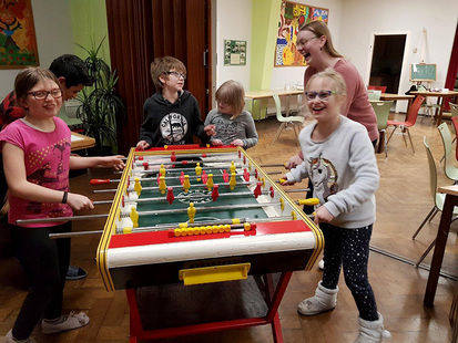 Spaß und Spiel im Küchwald. Die Kinder der Theatergruppe stehend spielend und lachend am Tischkicker. 