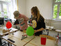 Jonas und Julia aus der 8. Klasse erklären interessante Physikexperimente mit farbigen Luftballons.