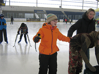 Elisabeth, weitere Kinder und Betreuer beim Fahren auf dem Eis.