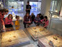 Schüler hocken mit der Museumspädagogin des »smac« um eine Glasvitrine. Darin befinden sich Ausgrabungsstücke.