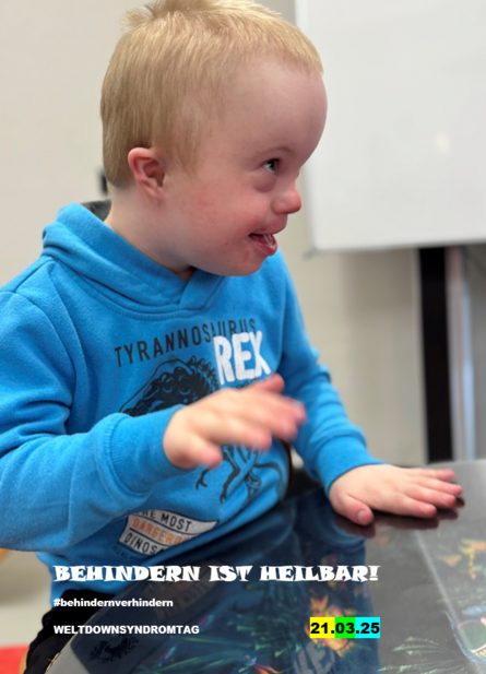 Eine Junge mit Down Syndrom sitzt an einem Tisch und hat Spaß daran, mit seinen Händen auf dem Tisch zu trommeln